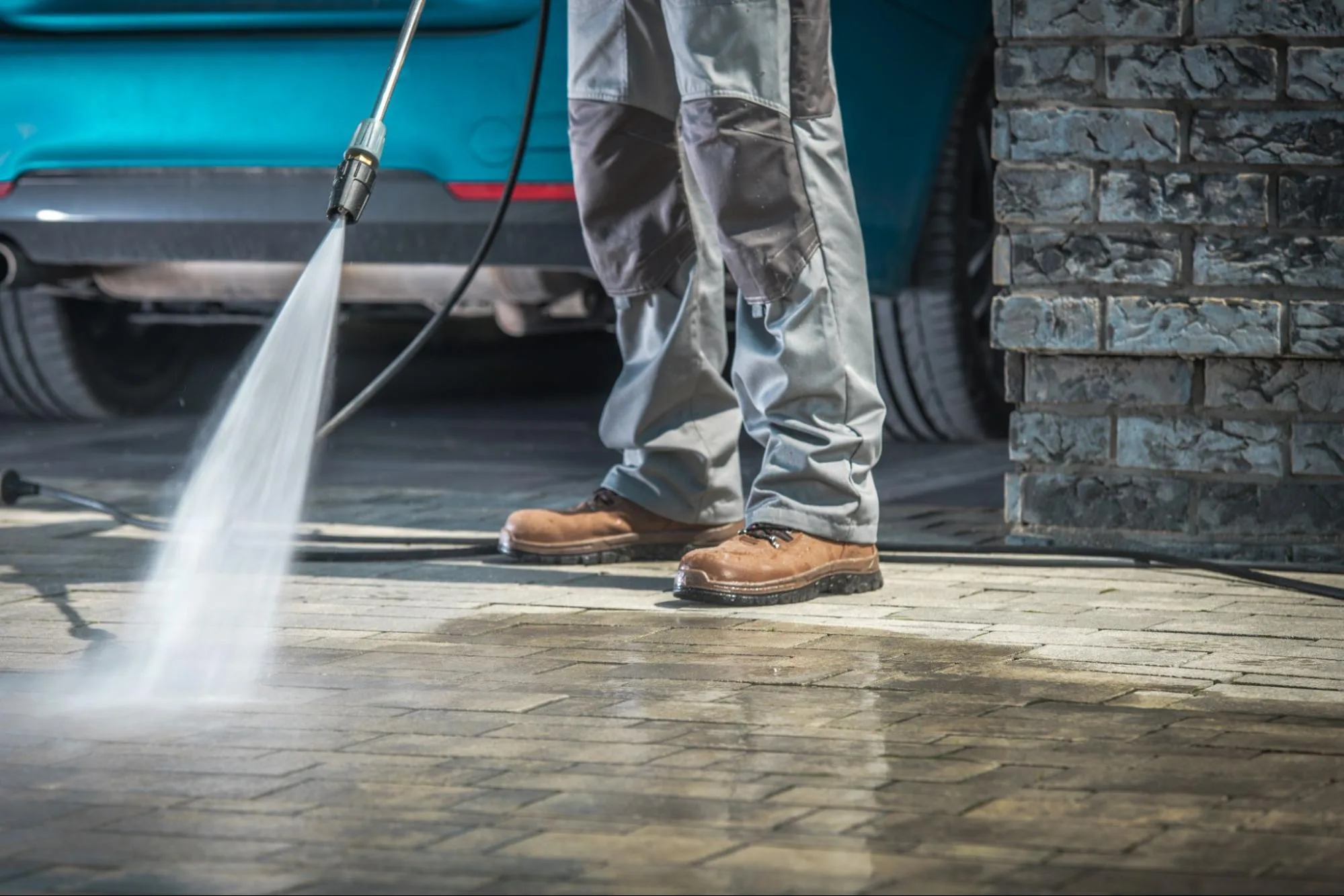 A professional cleaner washes the exterior house walls with a pressure washer