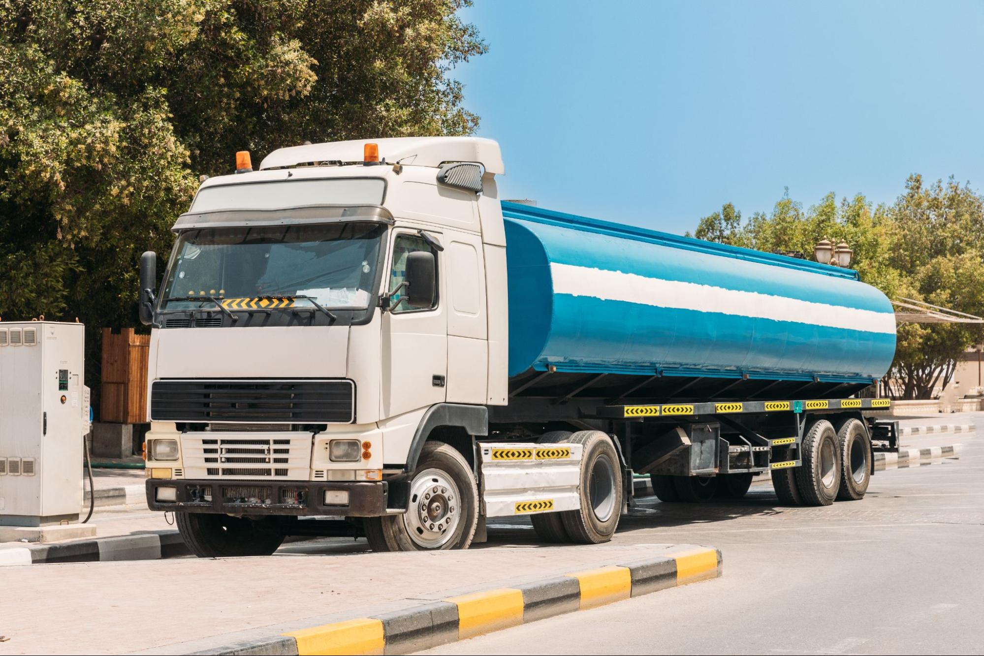 A white and blue water tanker truck for pool water delivery